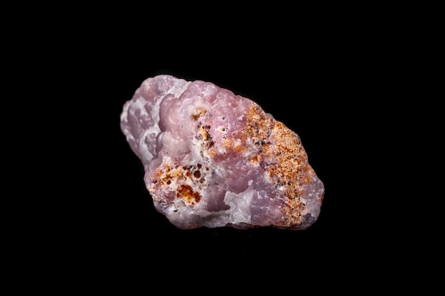 Pedra mineral de Smithsonite rosa macro em microclina em fundo preto