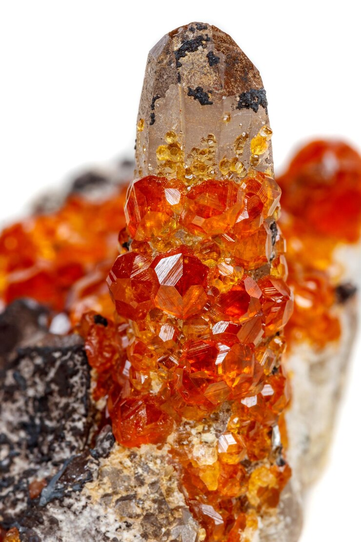 Foto pedra mineral macro spessartine granada vermelha alaranjada com quartzo no fundo branco