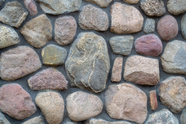 Pedra natural grande texturizada. fragmento de um muro de pedra colorido.