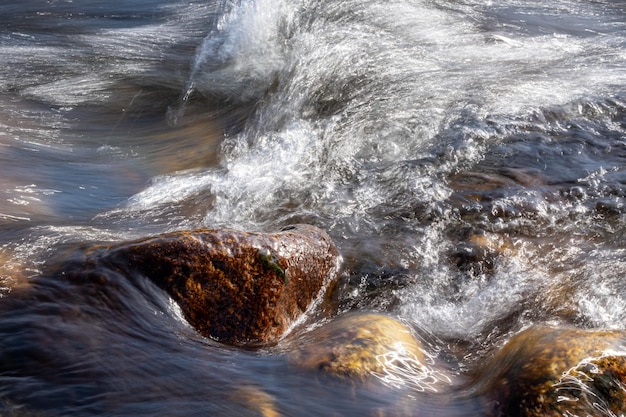 Pedra no fluxo furioso de um rio de montanha