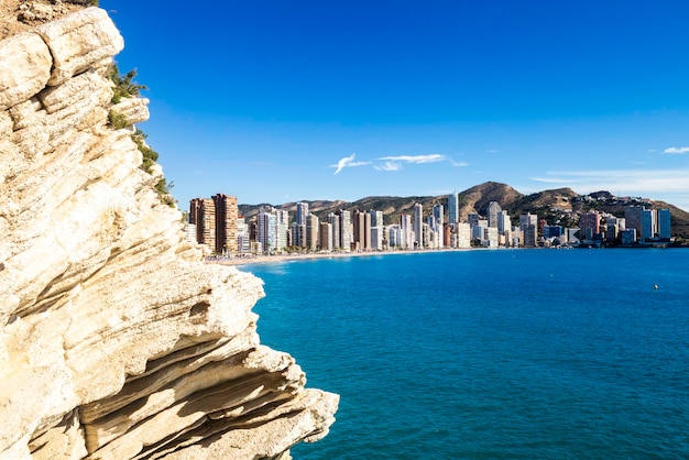 Pedra no fundo do panorama da cidade de Benidorm, Espanha, com arranha-céus e montanhas