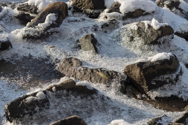 Pedras cobertas de gelo e neve fechadas Textura de pedras na neve Pedras marinhas cobertas por gelo