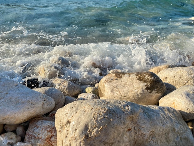 Pedras de rocha na praia do mar com fundo natural de verão de textura de água clara