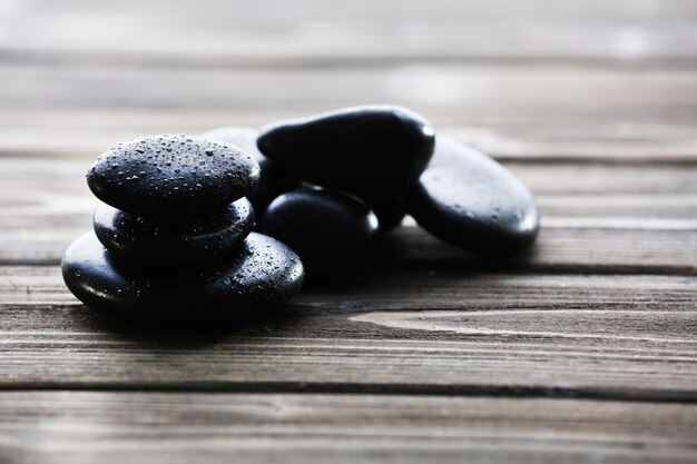 Foto pedras de spa com gotas de água no fundo de madeira