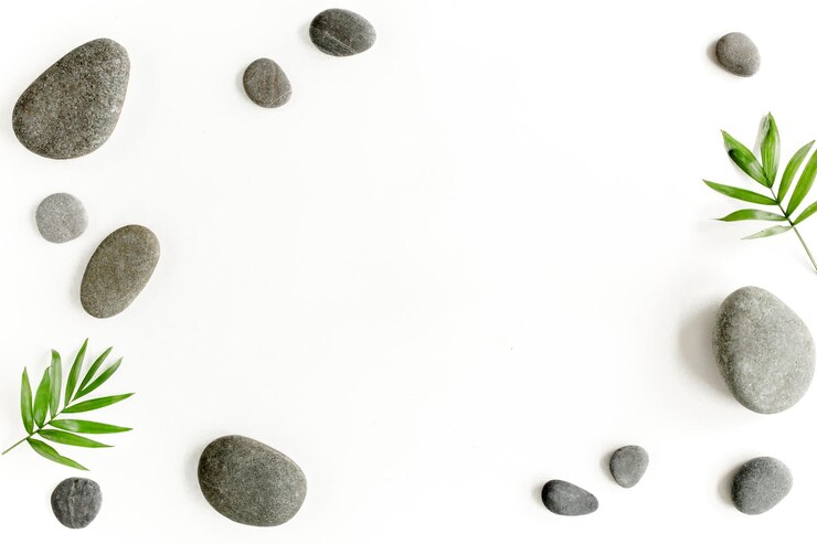 Pedras de spa folhas de palmeira vela e zen como pedras cinzentas em fundo branco plano lay vista superior