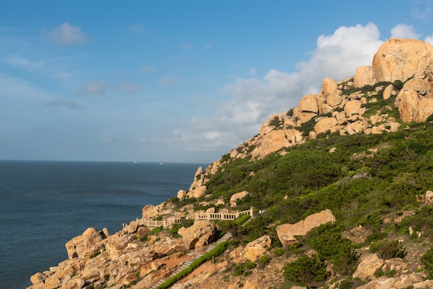 Pedras de várias formas intemperizadas pelo mar sob o céu azul