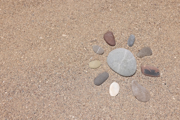 Pedras na areia em forma de sol closeup de fundo