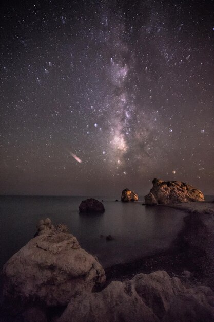 Pedras no mar contra o céu à noite