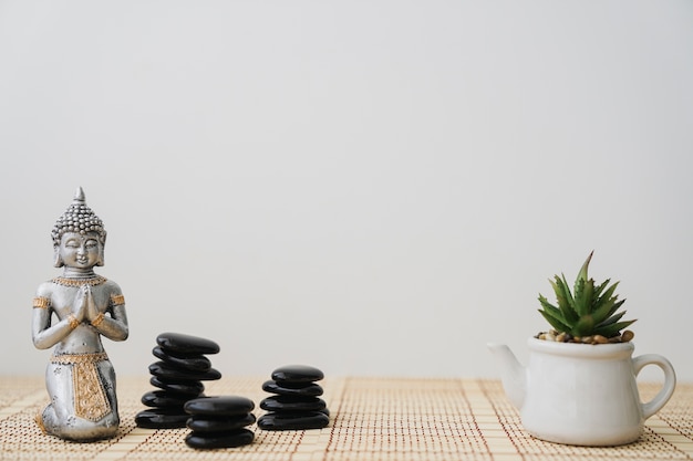 Foto pedras vulcânicas, buddha e vaso de flores