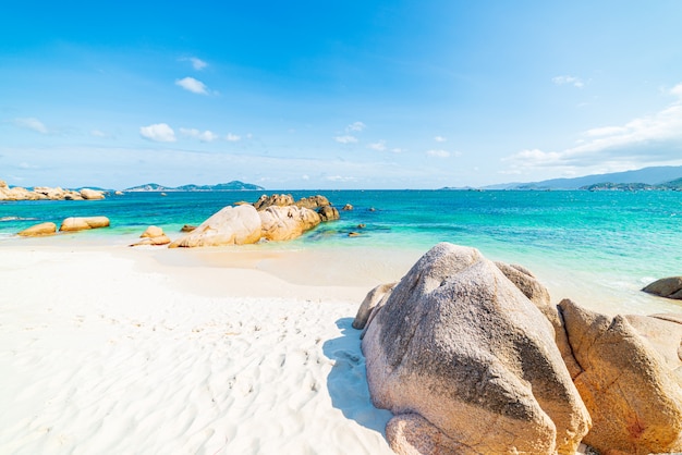 Pedregulhos exclusivos da rocha da água tropical turquesa lindo da praia transparente, destino de viagem da costa sudeste de Cam Ranh Nha Trang Vietnã, céu azul claro