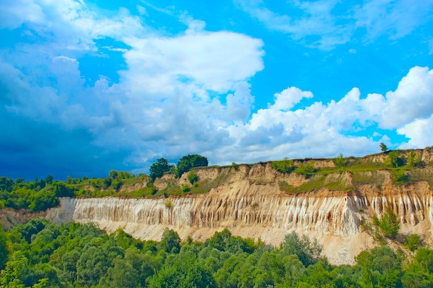 Pedreira do Cretáceo Paisagem com falésias arenosas e lindo céu Poço do Cretáceo Falésias arenosas com floresta ao pé Montanhas arenosas Paisagem celestial com depósitos de giz