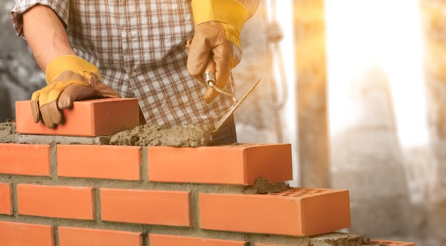 Foto pedreiro construtor arquitetura fundo bloco tijolo assentamento de tijolos