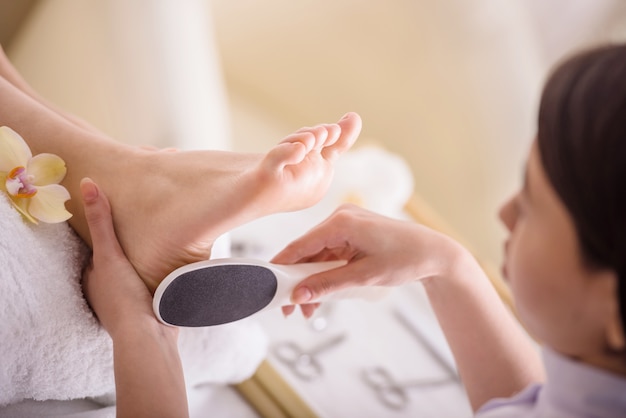 Peeling pés procedimento de pedicure em um salão de beleza.