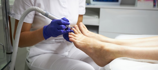 Peeling pés Procedimento de Pedicure SPA no salão de beleza. Aparelhos elétricos para pedicura. Mulher tendo os pés descascados em centro de spa