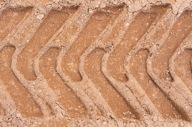 Foto pegada de pneu de carro em uma textura de estrada de cascalho de areia estrada de campo de fundo texturizado para fundo de várias ideias pequenas pedras de terra abstracto areia superfície áspera efeito de moda sem pessoas pneu