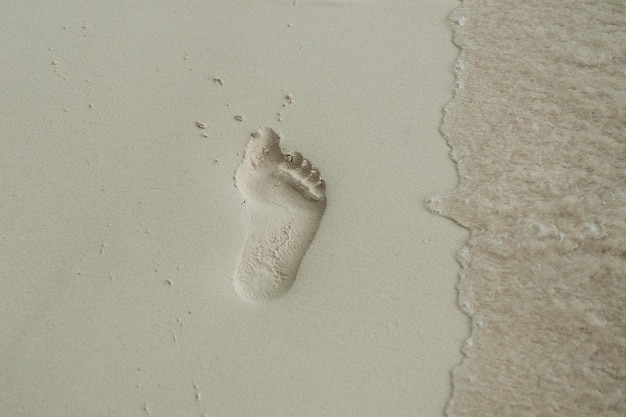 Pegada na areia da praia. Conceito de férias tropicais