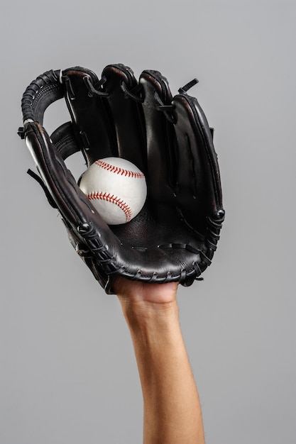 Pegando beisebol com luva de beisebol de couro sobre fundo cinza
