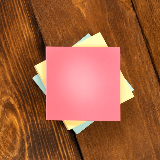 Pegatinas de colores en blanco en la mesa de madera marrón