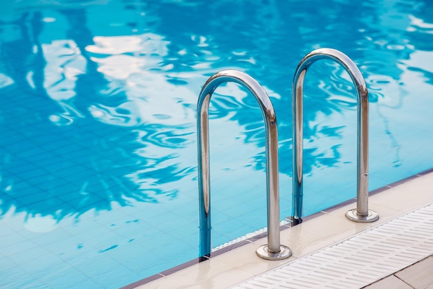 Foto pegue a escada de barras na piscina azul