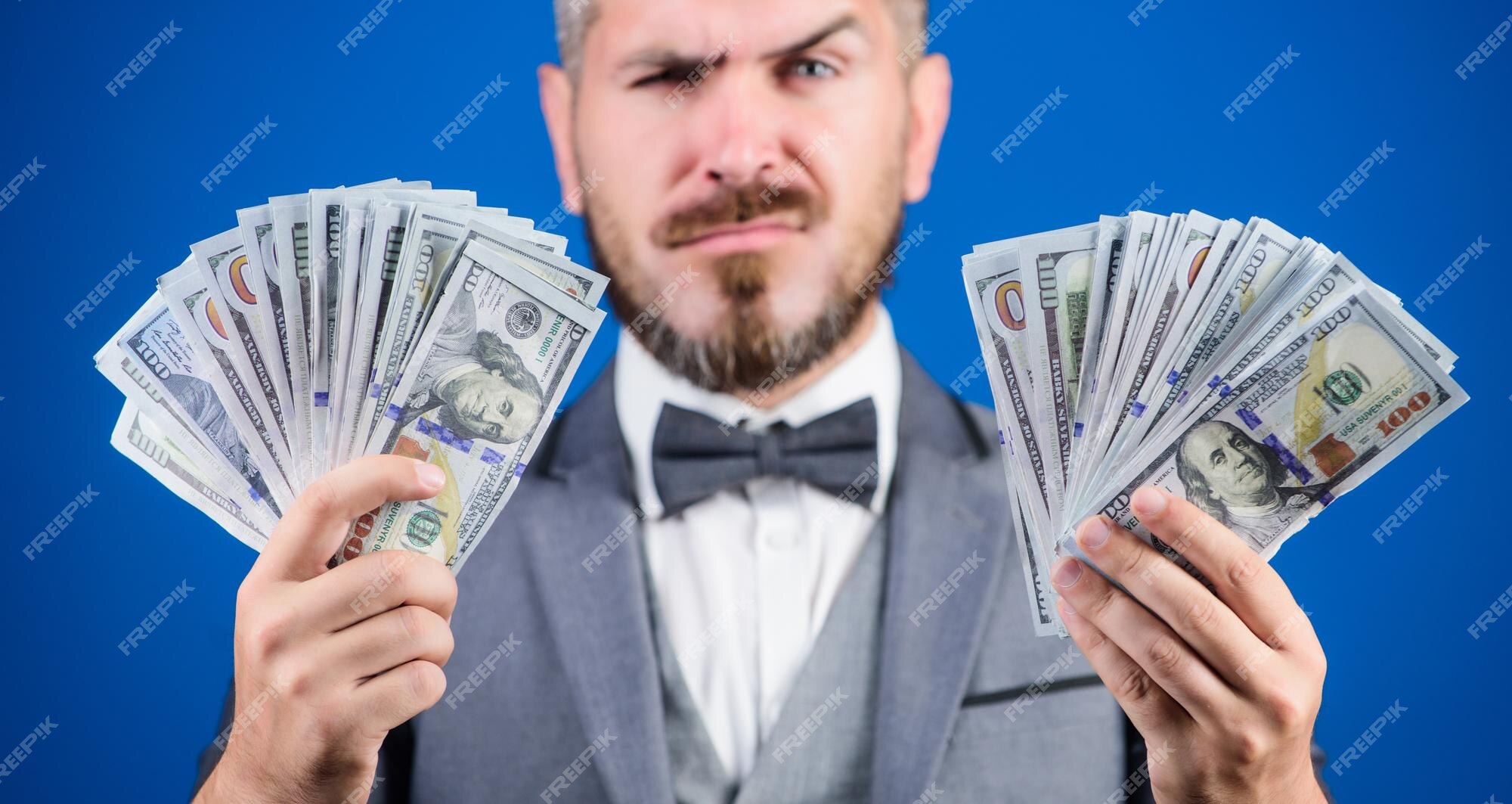 Empréstimo de dinheiro fácil homem terno formal segura muitas notas de  dólar fundo azul empresário tem dinheiro pegue meu dinheiro ganhe dinheiro  real conceito de riqueza e bem-estar negócios de transações em