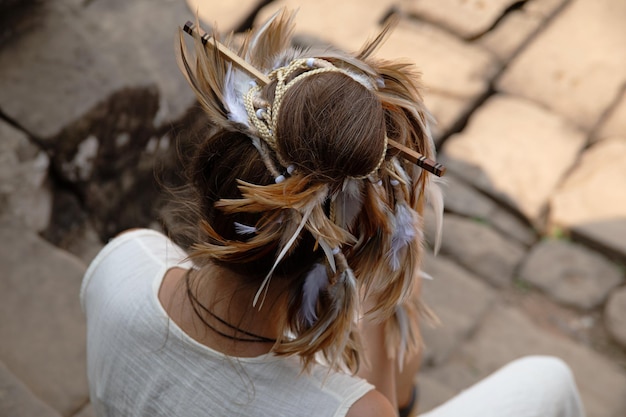 Peinado elegante femenino con trenzas de plumas y palillos