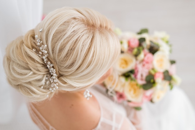 Foto peinado de la novia. un moño bajo en su cabello rubio. vista trasera y superior