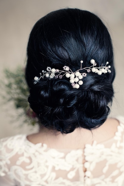 Peinado nupcial o de graduación con perlas blancas Hairdeco en cabello negro de mujer morena