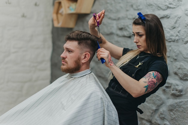 Peinado profesional en barbería de niña en tatuaje