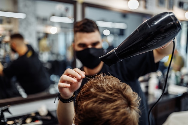 Peinar el cabello de los hombres. El peluquero hace un peinado elegante. Estilo de vida en una barbería.