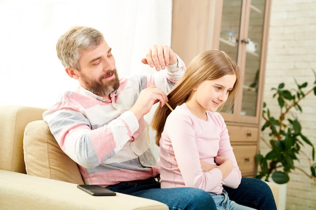 Peinar el cabello de la pequeña hija