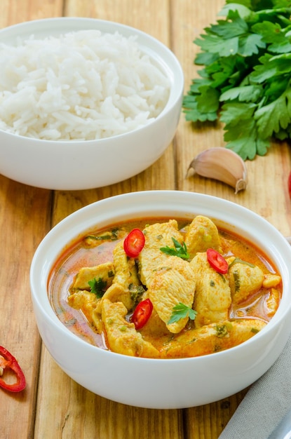 Peito de frango apimentado em molho de curry amarelo com alho e pimenta com arroz cozido em uma tigela