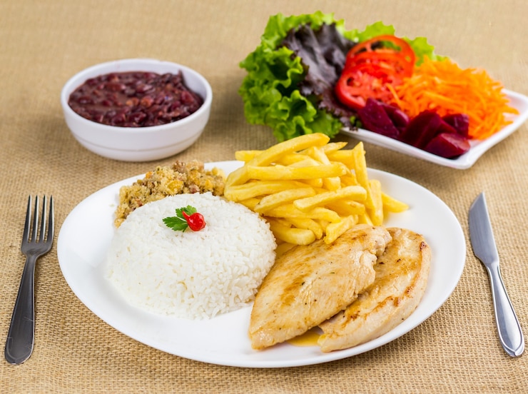 Foto peito de frango, arroz, feijão, batata e migalhas com acompanhamentos