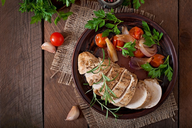 peito de frango assado saudável com legumes em um prato de cerâmica em estilo rústico