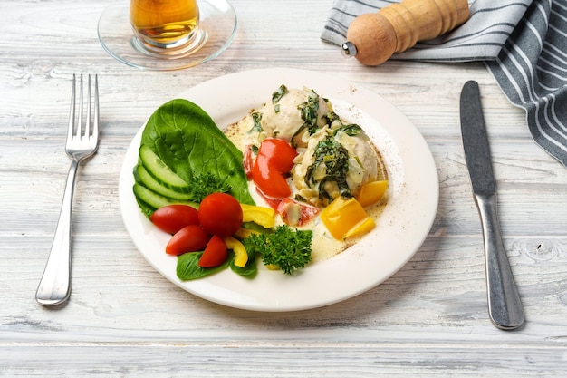 Peito de frango cozido em molho e legumes frescos servidos no prato no café