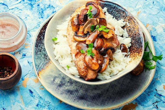 Peito de frango estufado com molho de cogumelos marsala e arroz.