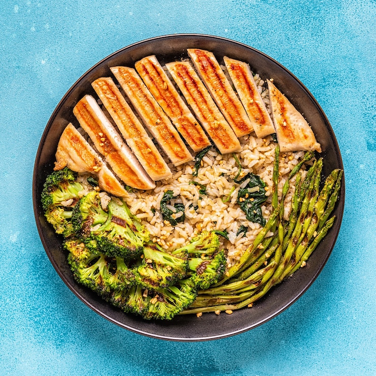 Foto peito de frango grelhado com arroz integral, espinafre, brócolis, aspargos, conceito de dieta, alimentação saudável.