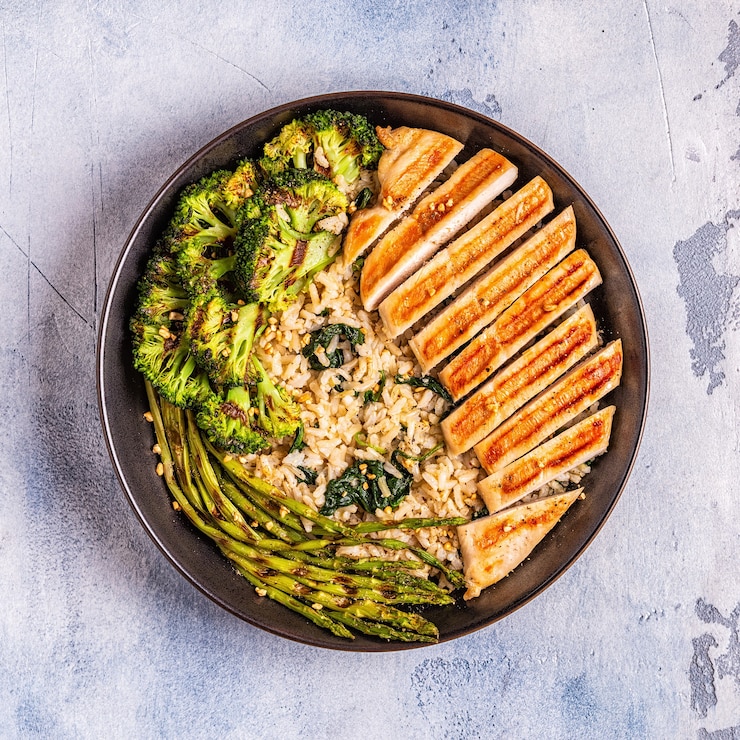 Foto peito de frango grelhado com arroz integral, espinafre, brócolis, aspargos, conceito de dieta, alimentação saudável.