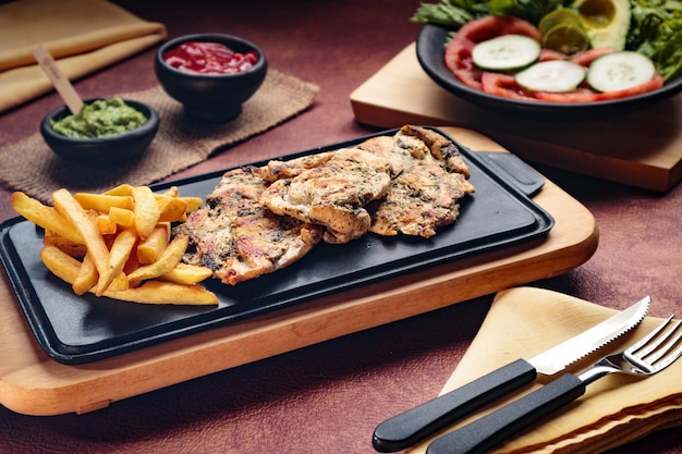 Peito de frango grelhado do Dia Mundial da Alimentação com batatas fritas na sala de jantar comida saudável