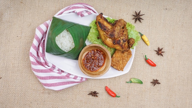 Peito de frango grelhado indonésio na chapa branca Servido com arroz sambal frito tempeh e alface