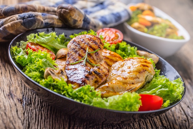 Peito de Frango Grelhado. Peito de frango assado e grelhado com salada de alface, tomate e cogumelos.