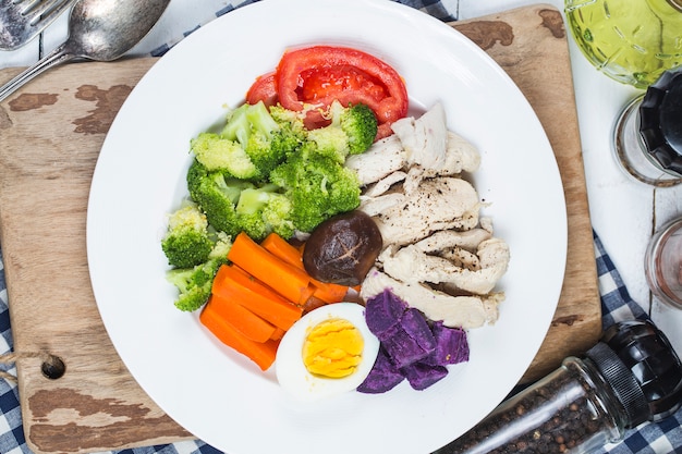 Peitos de frango cozidos e legumes com esportes e conceitos de dieta.