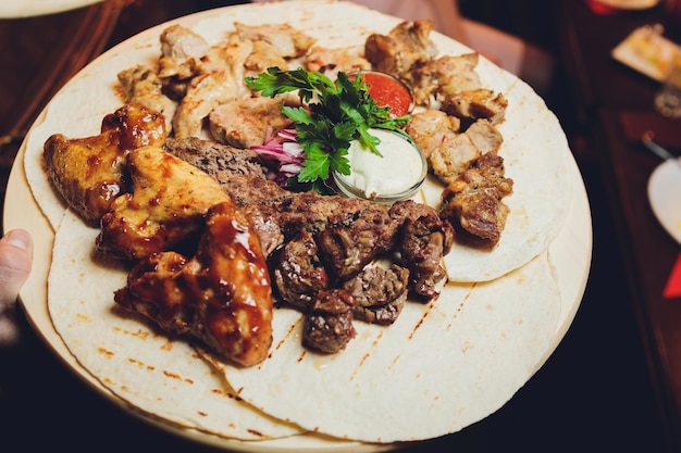 Peitos de frango grelhados e vegetais diferentes e cogumelos cozidos em um churrasco servido em tábua de madeira Vista de perto Conceito de jantar de churrasco de verão caseiro