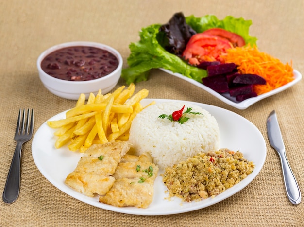 Peixe, arroz, feijão, batata e migalhas com acompanhamentos