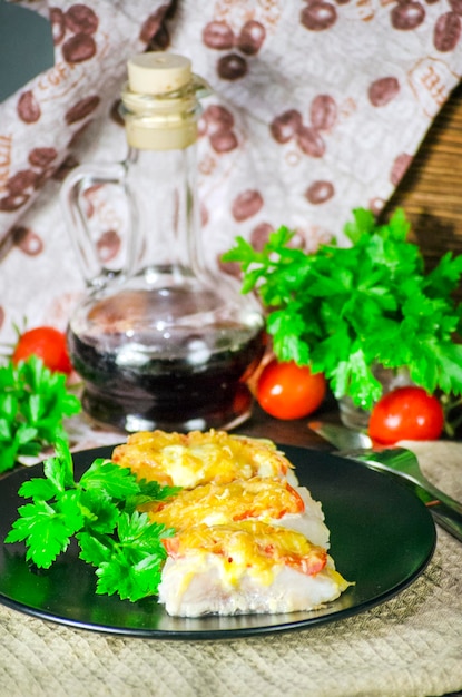 Foto peixe assado com legumes e queijo em molho branco sobre fundo escuro