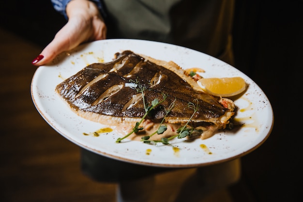 Peixe assado com limão em um prato redondo