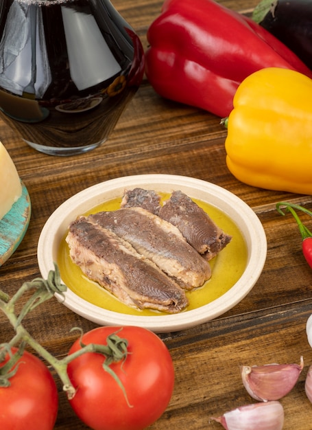 Peixe, azeite, vinho e legumes sobre a mesa de madeira. Comida mediterrânea.