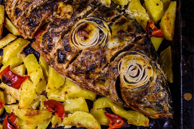 Foto peixe carpa assado com batatas e pimentão vista superior