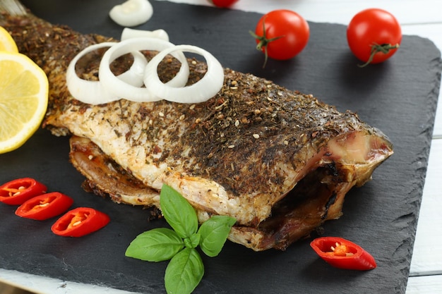 Peixe carpa frito na mesa Peixe assado com legumes