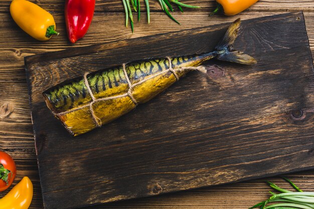 Peixe cavala fumado em uma placa com tomate e pimenta