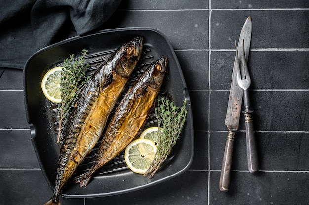 Peixe cavala grelhado com ervas de limão e especiarias em uma frigideira Fundo preto Vista superior